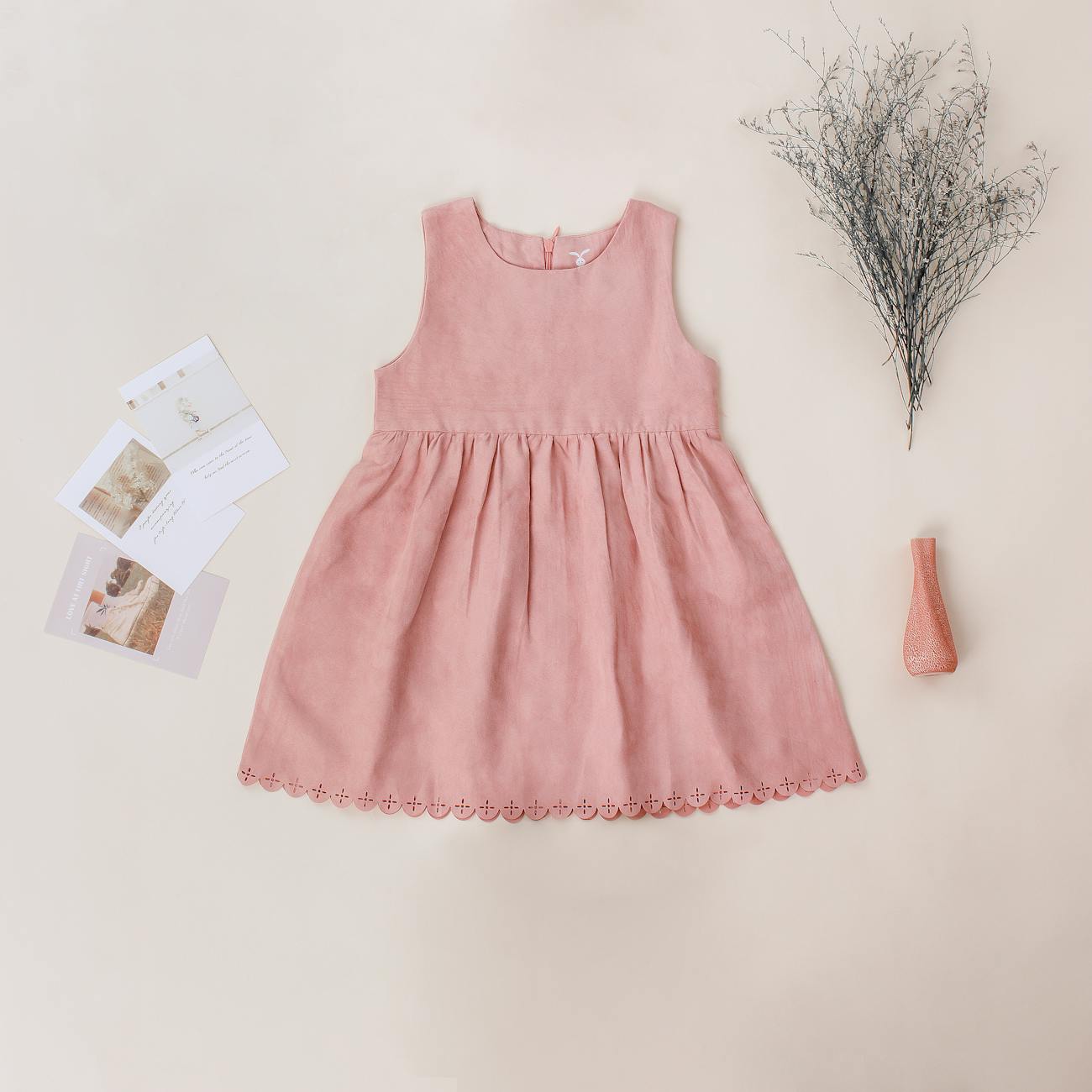 trendy dress for girl near postcards on beige background